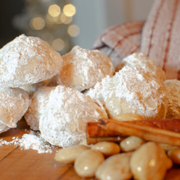 Cinnamon Spice Snowball Cookies with Marcona Almonds and Cinnamon Sticks Near a Christmas Tree