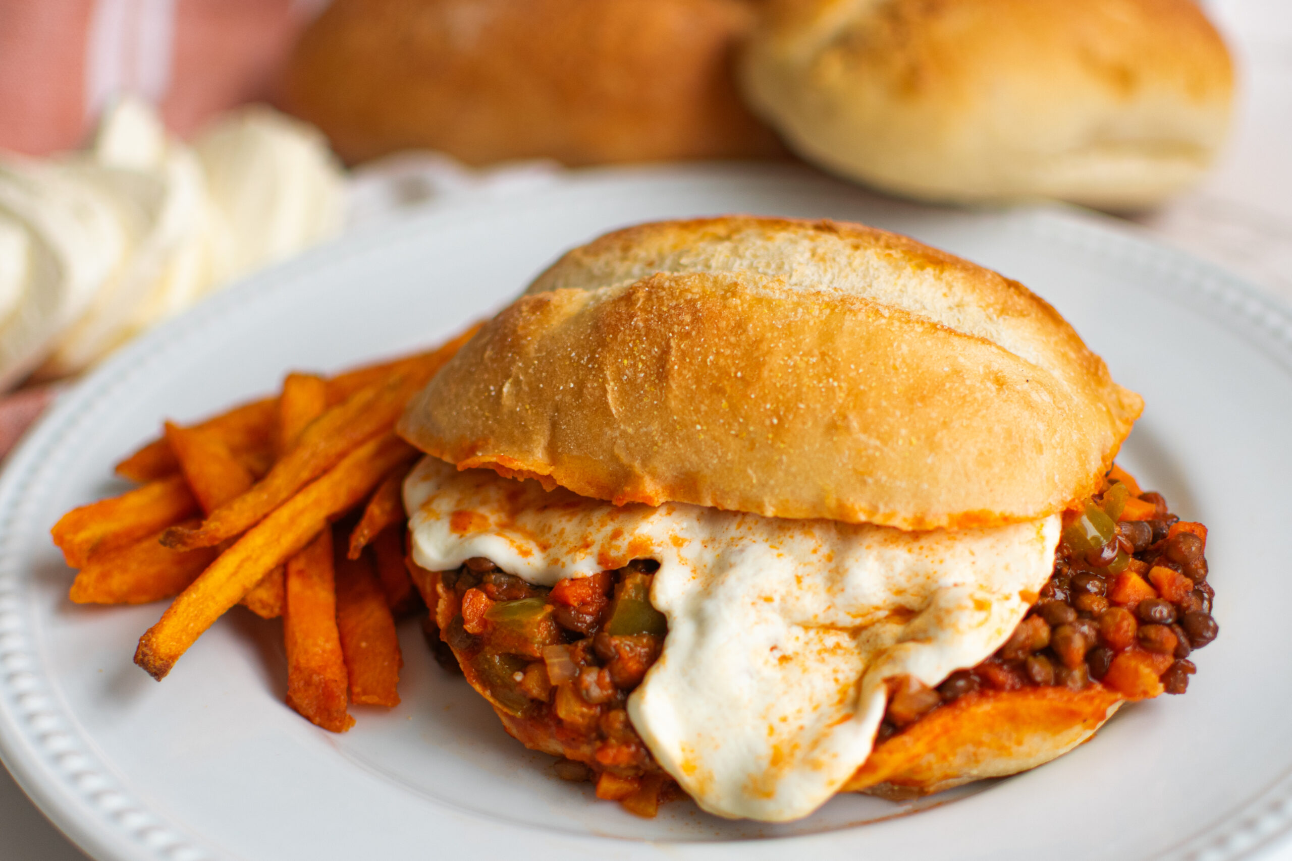 meatless lentil sloppy joe with melted mozzarella cheese sandwich with sweet potato fries