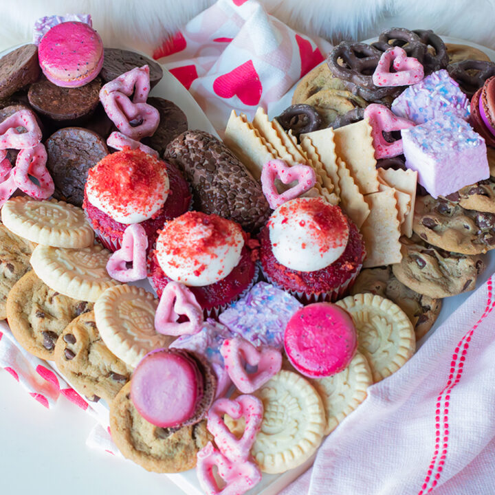 Valentine’s Day graze board with heart-shaped pretzels, cookies, fresh fruit, cheese, and chocolate.