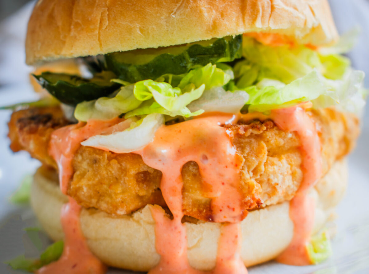 Crispy KFC Kentucky Fried Cauliflower Sandiwch with fresh toppings like Lettuce, Pickles and spicy topping on a bun