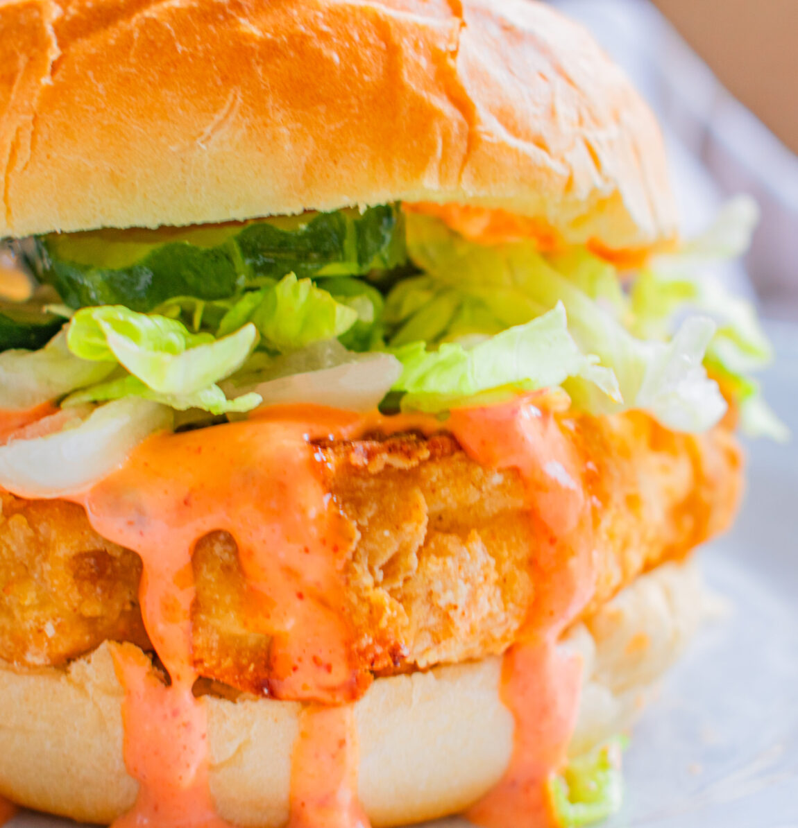 Crispy KFC Kentucky Fried Cauliflower Sandiwch with fresh toppings like Lettuce, Pickles and spicy topping on a bun