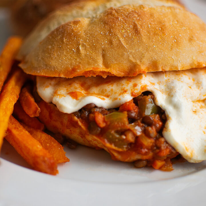 meatless lentil sloppy joe with melted mozzarella cheese sandwich with sweet potato fries