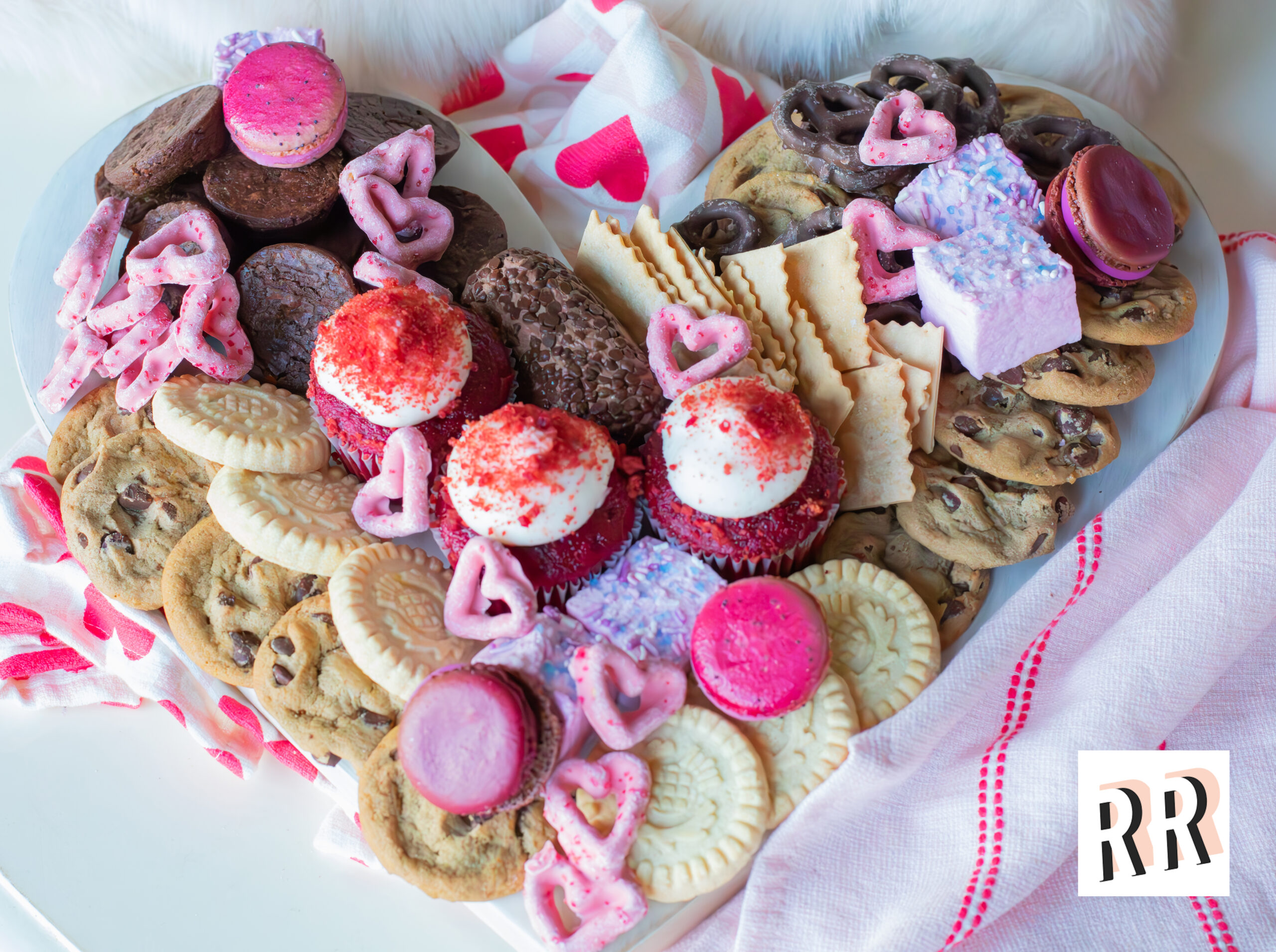 Valentine’s Day graze board with heart-shaped pretzels, cookies, fresh fruit, cheese, and chocolate.