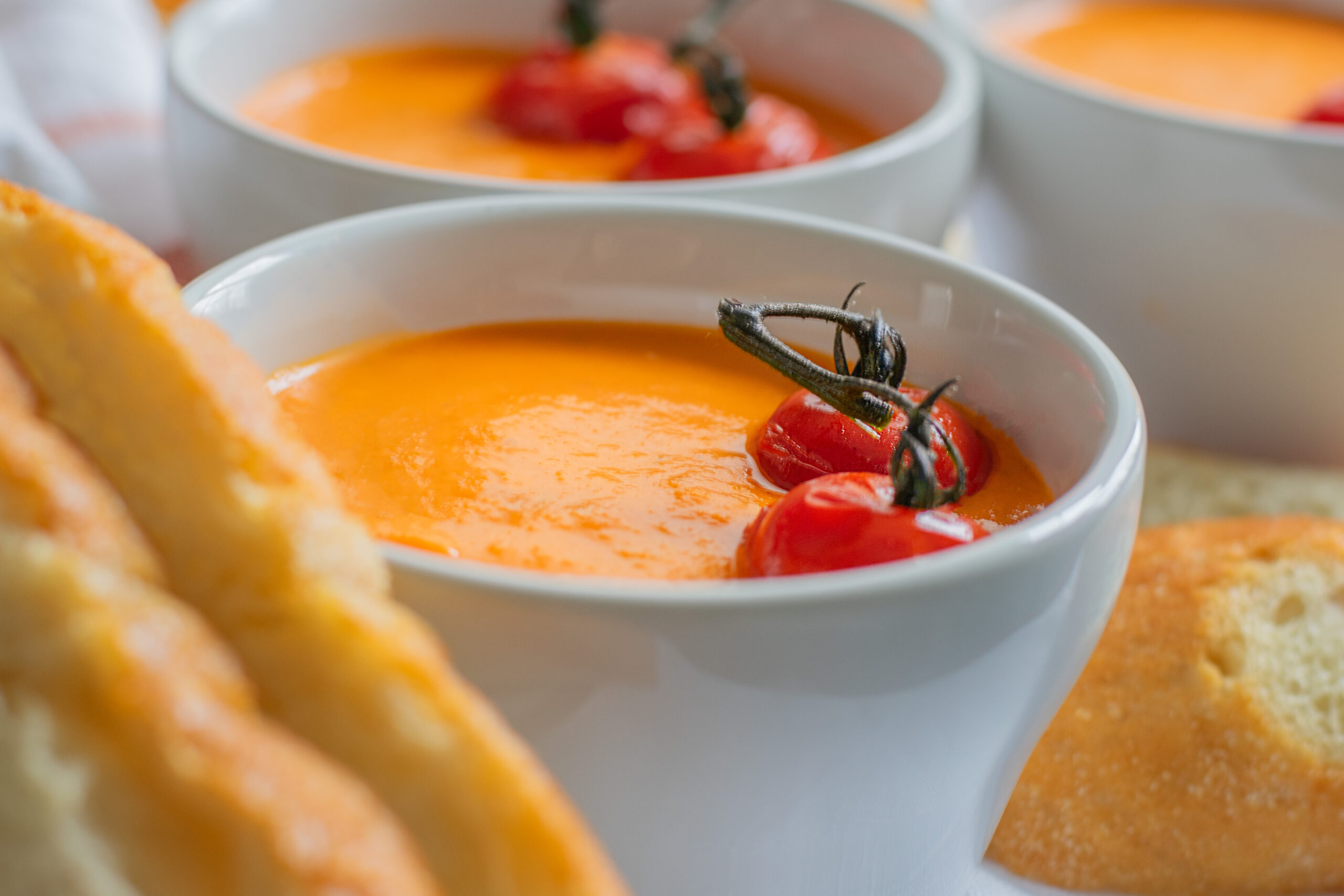 Delicious homemade roasted tomato soup served with crusty bread, topped with fresh herbs and a swirl of cream—perfect for cozy meals and comfort food lovers.