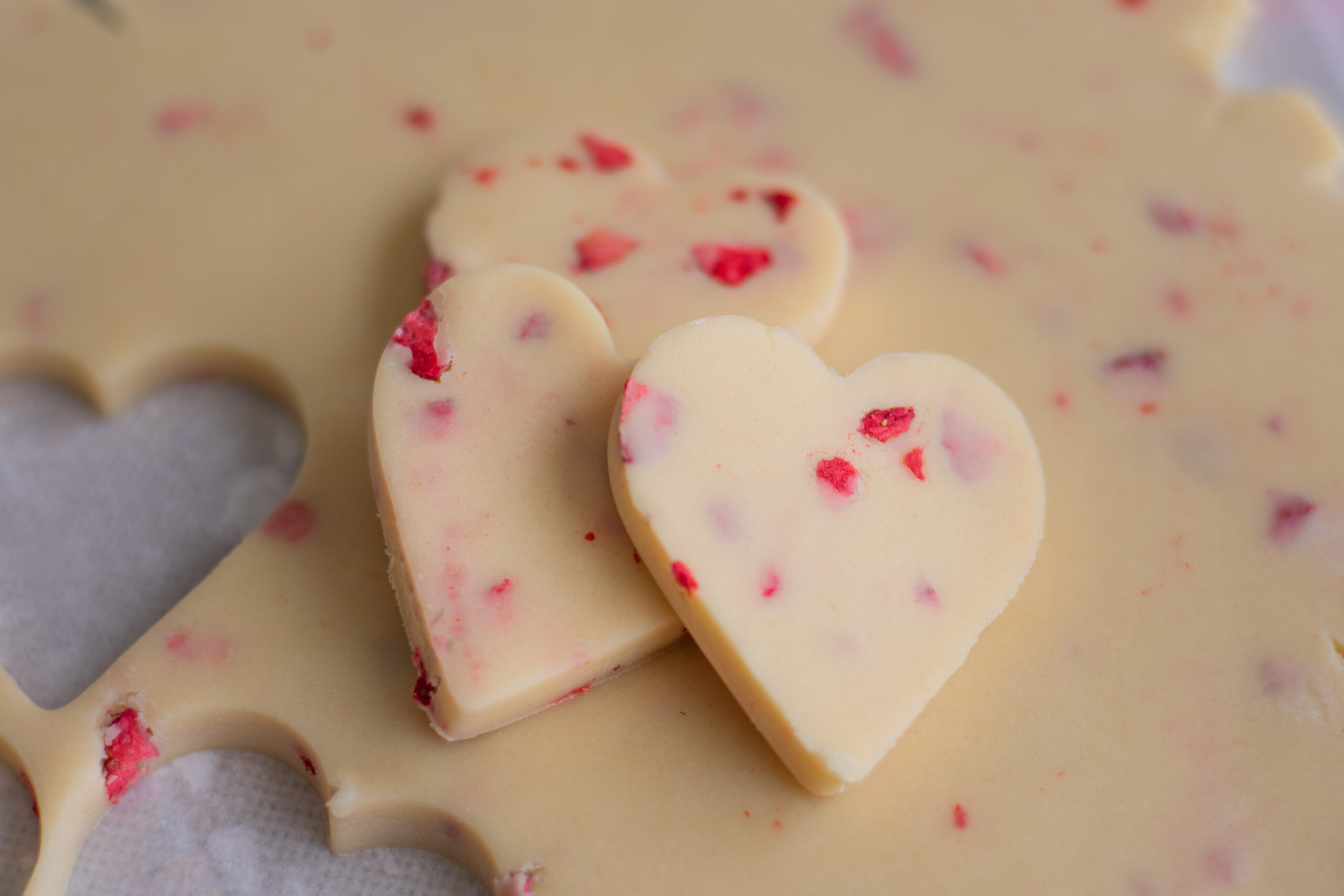 Strawberry Flecked Shortbread Cookie Dough with heart shaped cookies cut out on top