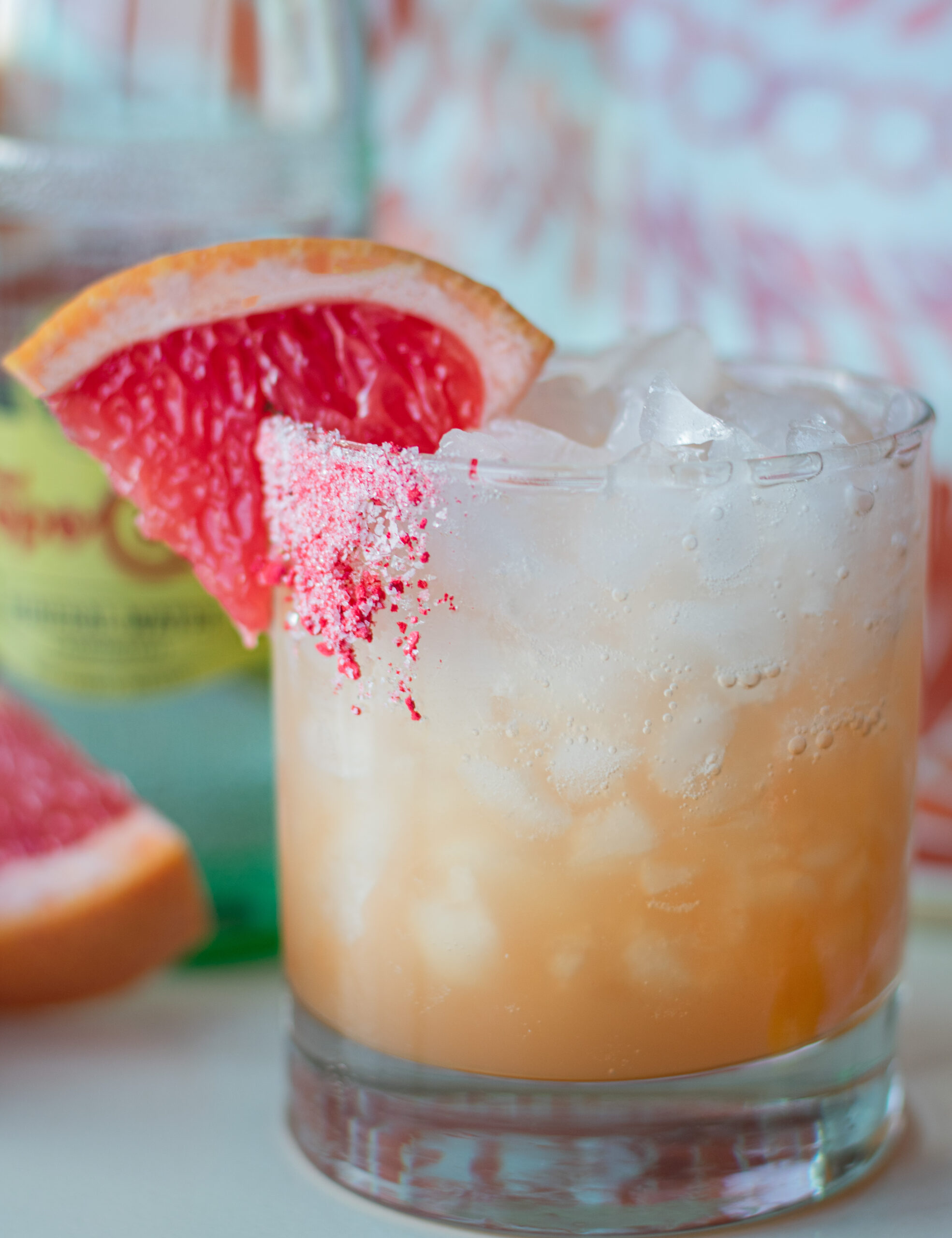 Refreshing Paloma mocktail with ruby red grapefruit, fizzy mineral water, agave, and a grapefruit slice garnish on a salty sweet rim.