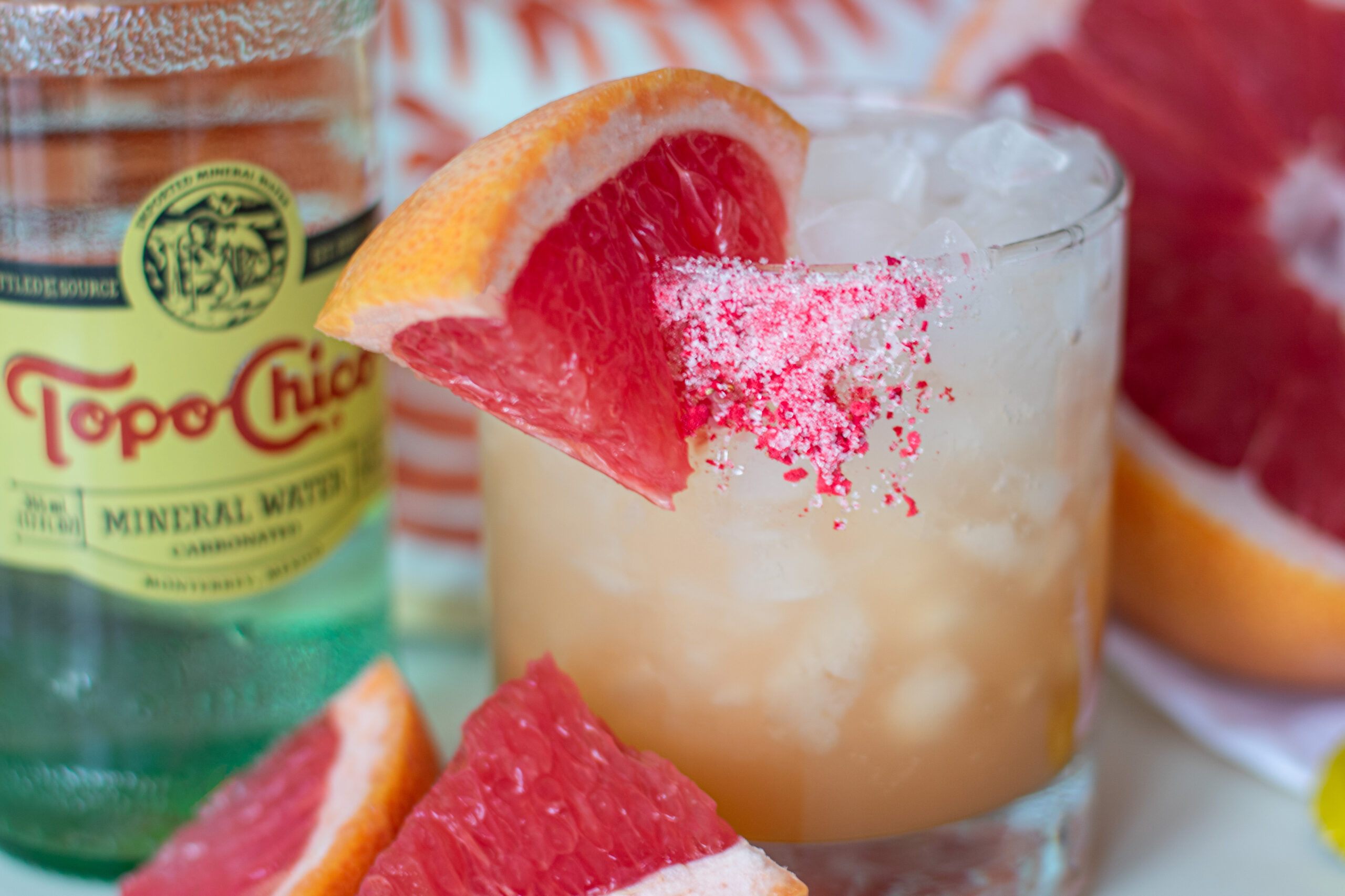 Refreshing Paloma mocktail with ruby red grapefruit, fizzy mineral water, agave, and a grapefruit slice garnish on a salty sweet rim.