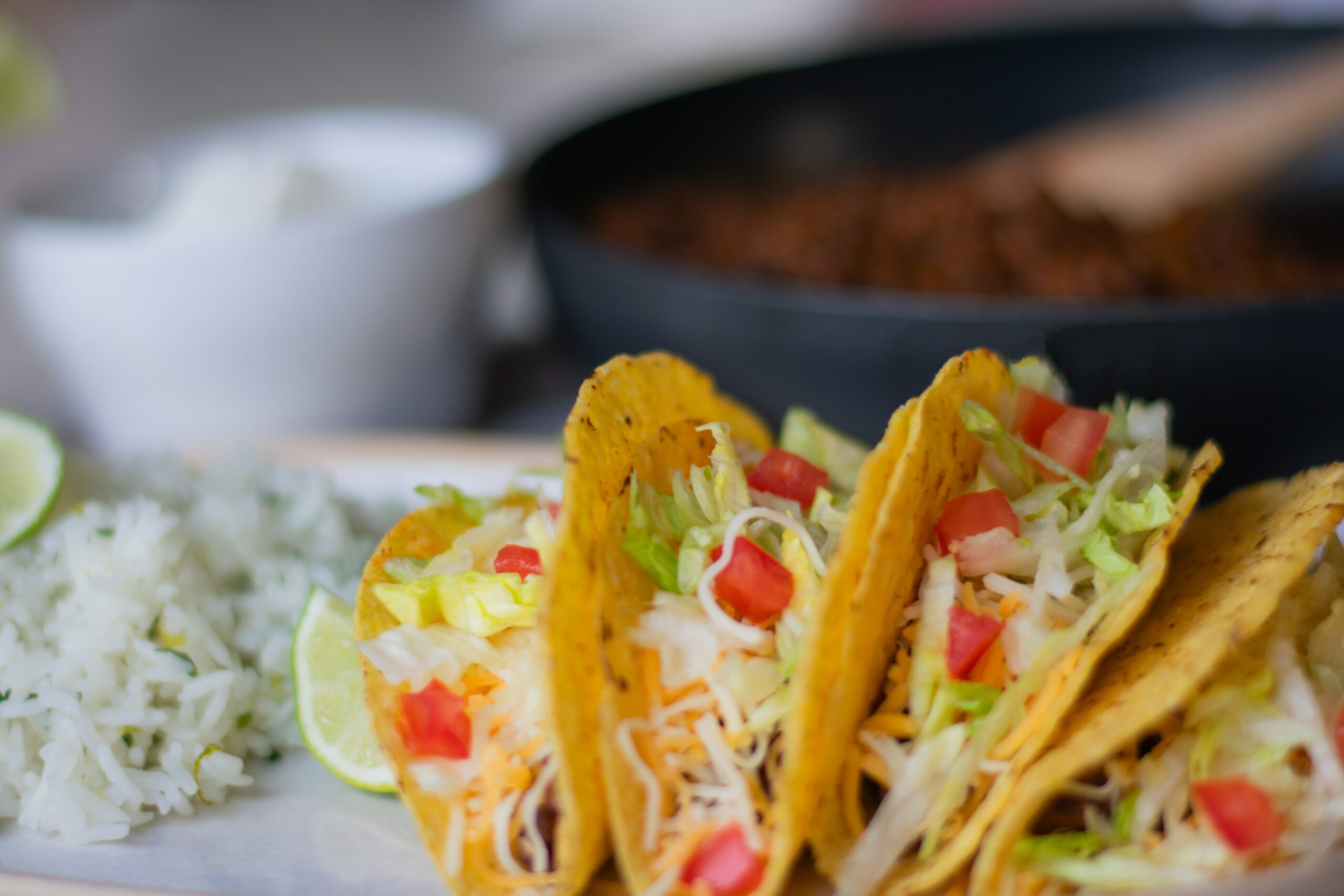 Vegetarian tacos served alongside flavorful lentil filling, topped with crisp lettuce and fresh tomatoes, with a refreshing margarita on the side.