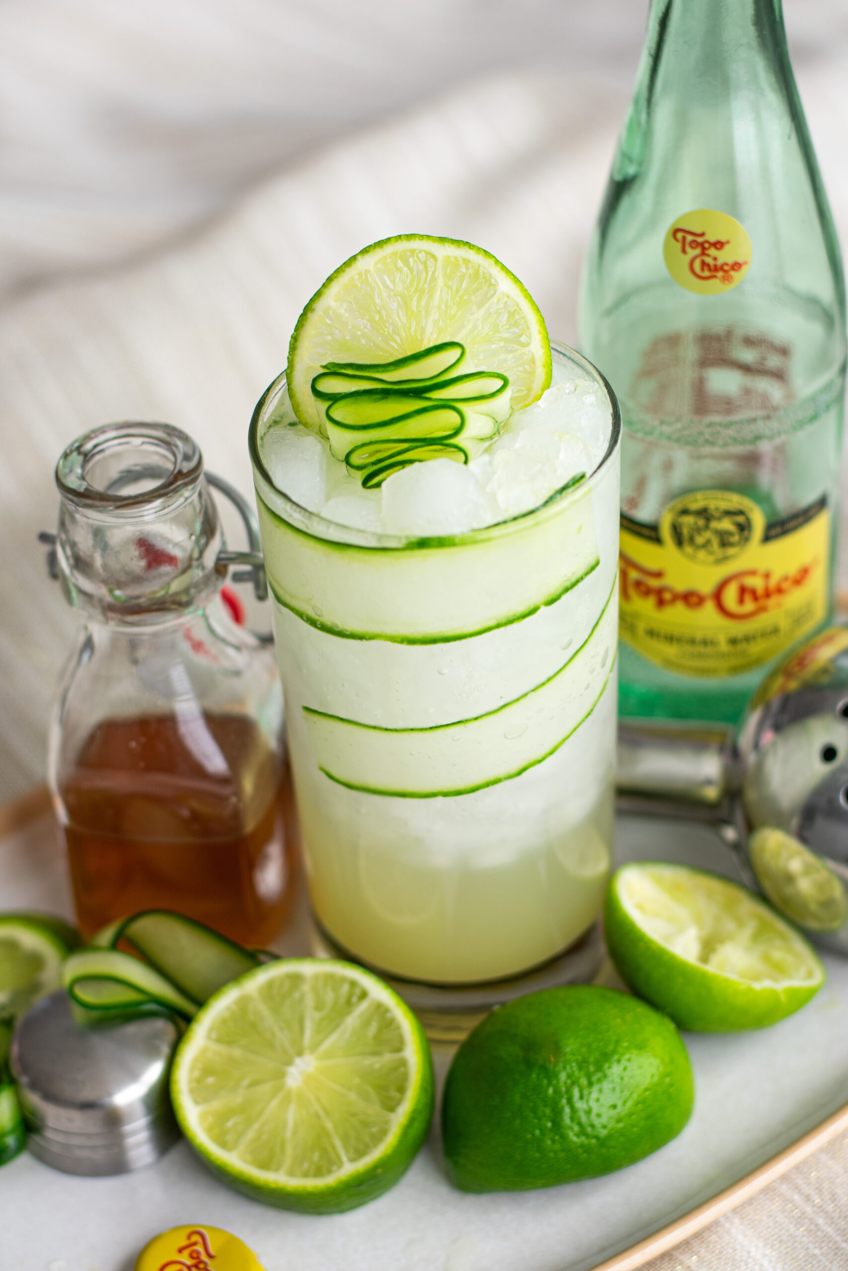 Zero-Proof Gin alongside Cucumber Lime Gimlet Mocktail made with Topo Chico Mineral Water