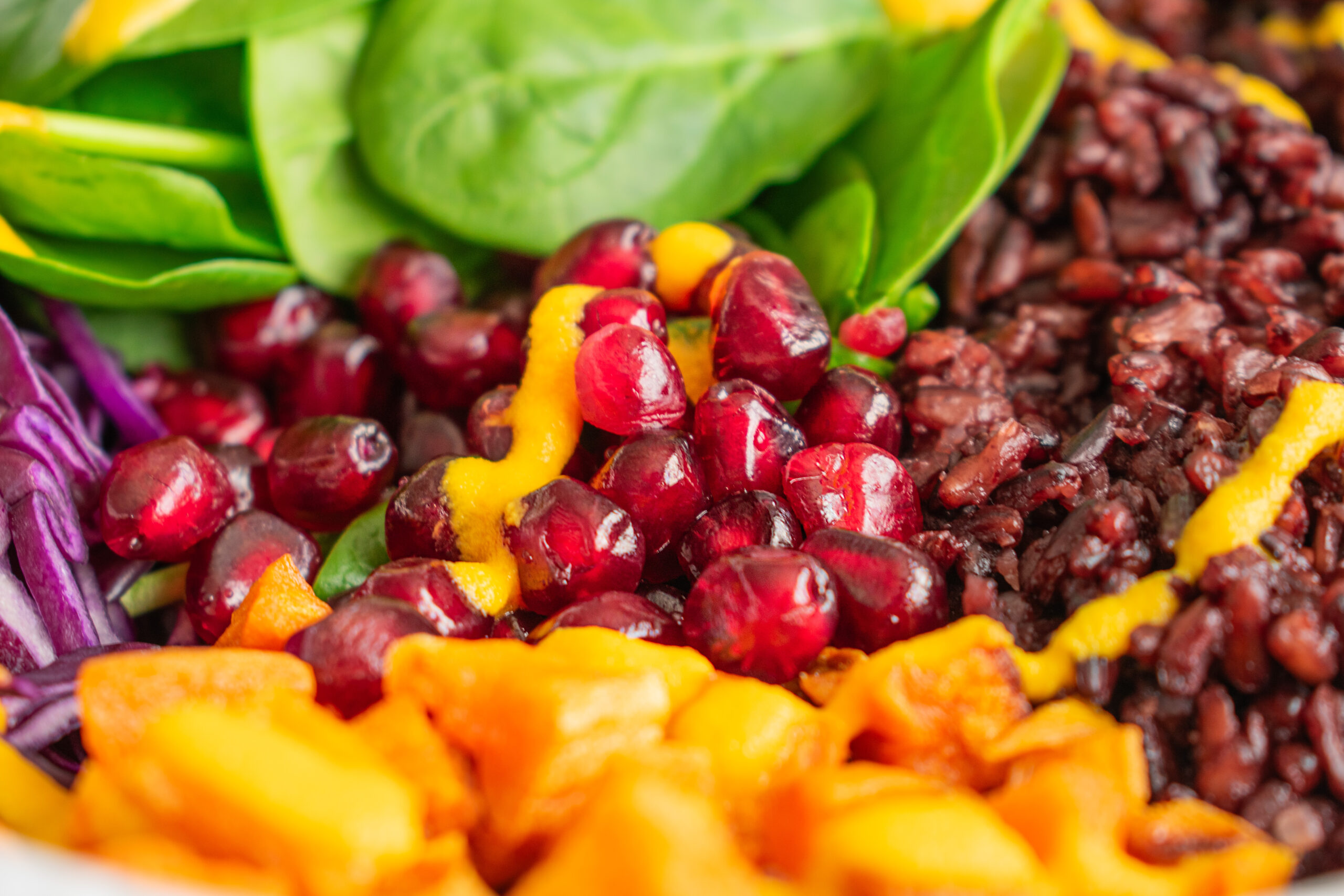 Winter Glow Buddha Bowl with black rice, roasted sweet potatoes, pomegranate seeds, and a drizzle of tangy dressing. A colorful and healthy meal for mindful eating.