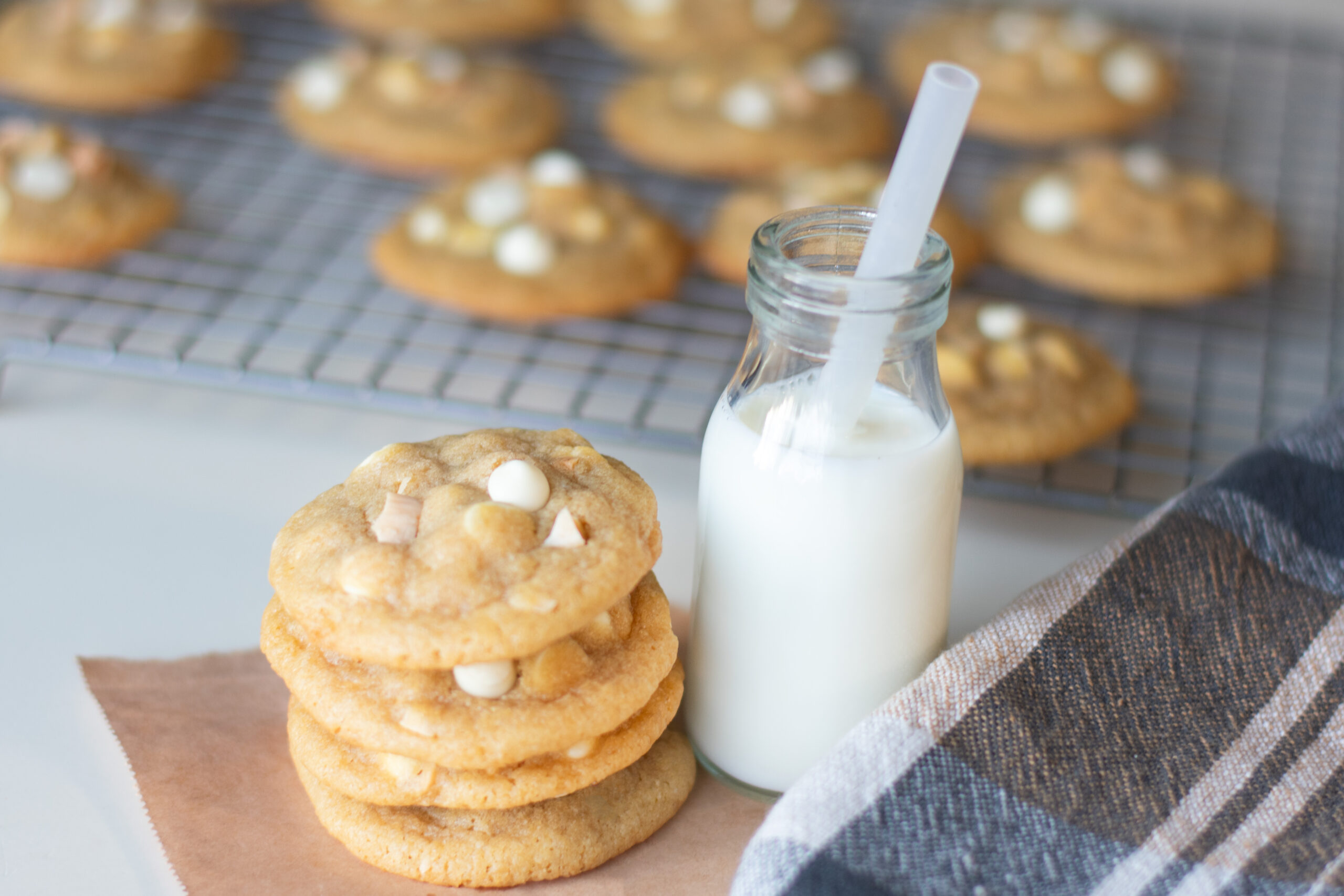 White Chocolate Chip Marcona Cookies next to a glass of milk with a straw