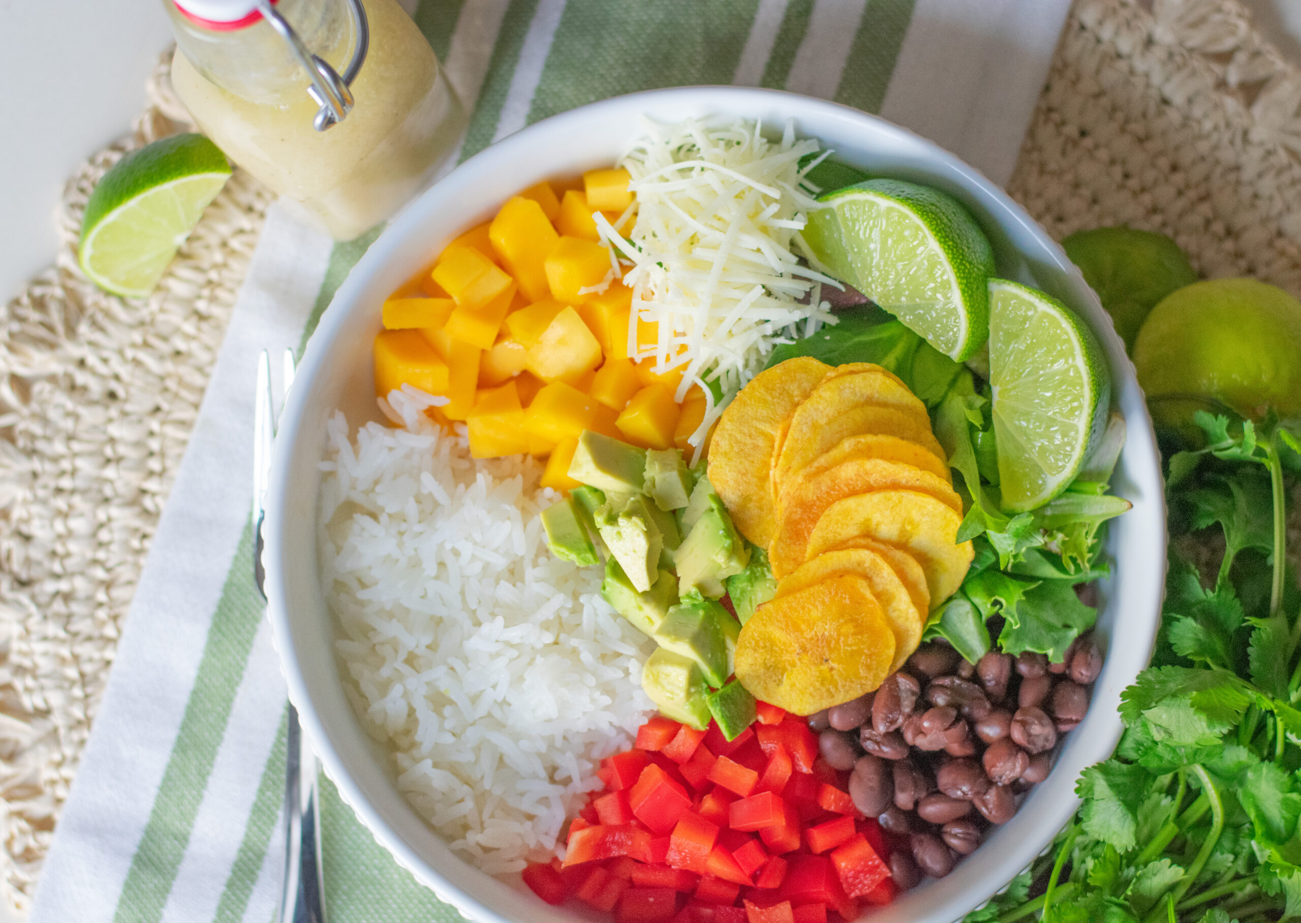 Cuban Salad Bowl with creamy Manchego cheese, juicy mango, and crisp greens, drizzled with lime vinaigrette.