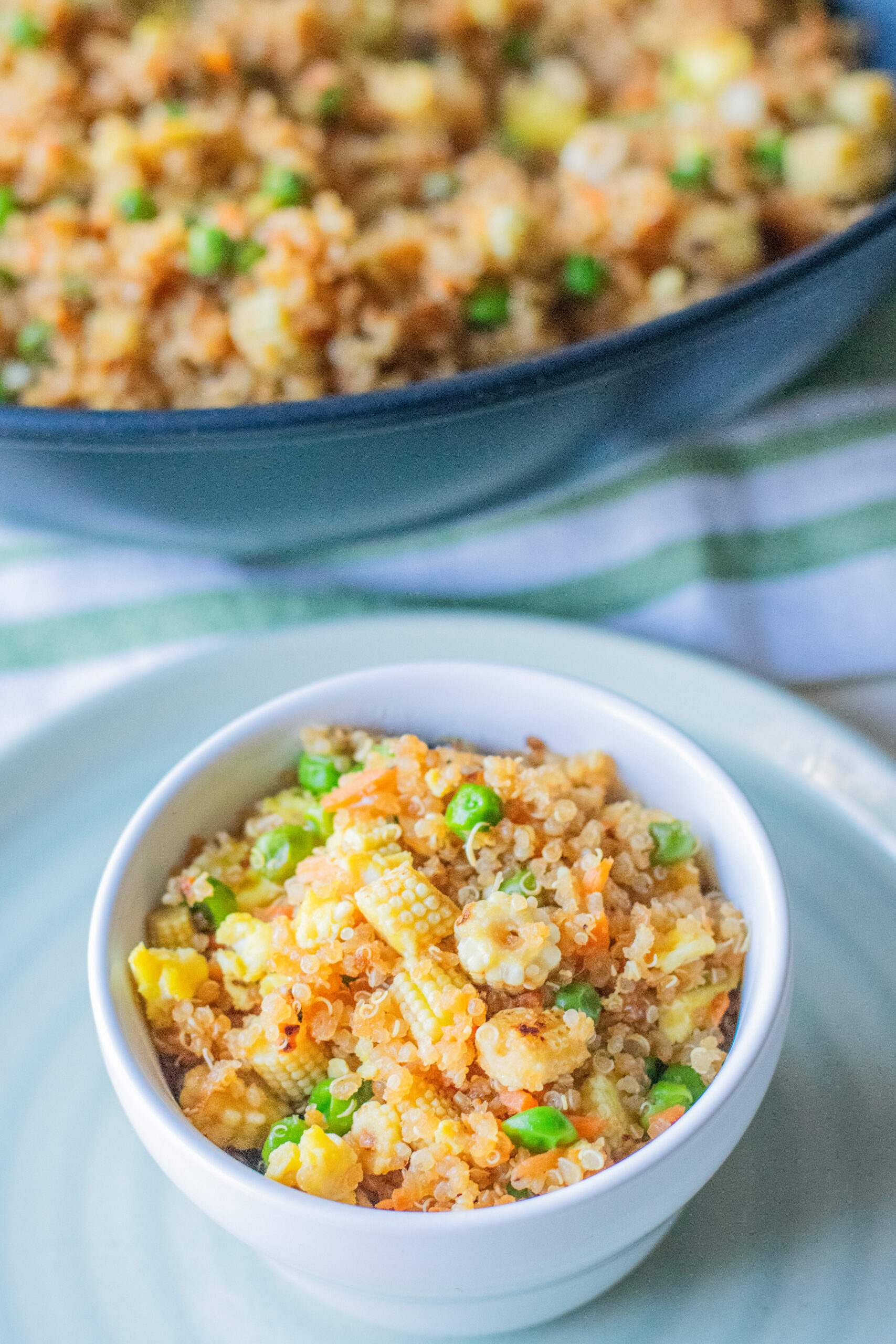 Close-up of quinoa fried rice featuring carrots, peas, and baby corn
