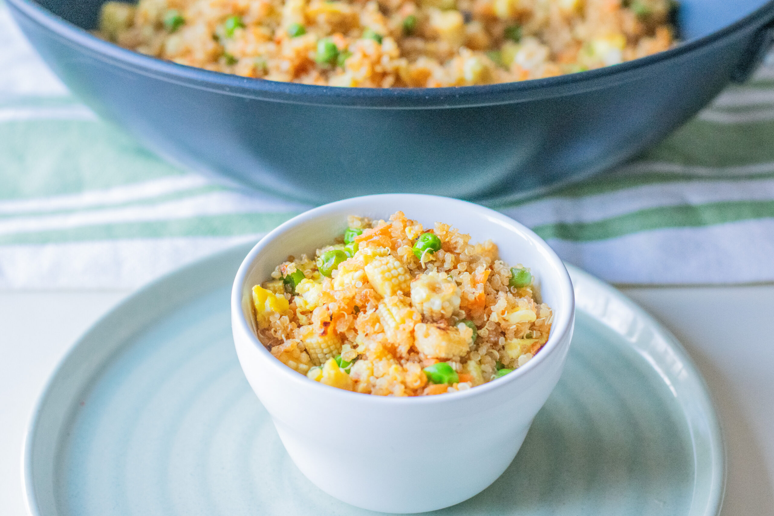 Large pot of quinoa fried rice with a small serving bowl beside it