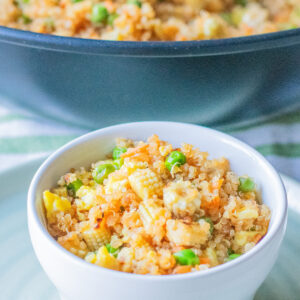 Quinoa fried rice with colorful vegetables in a white bowl