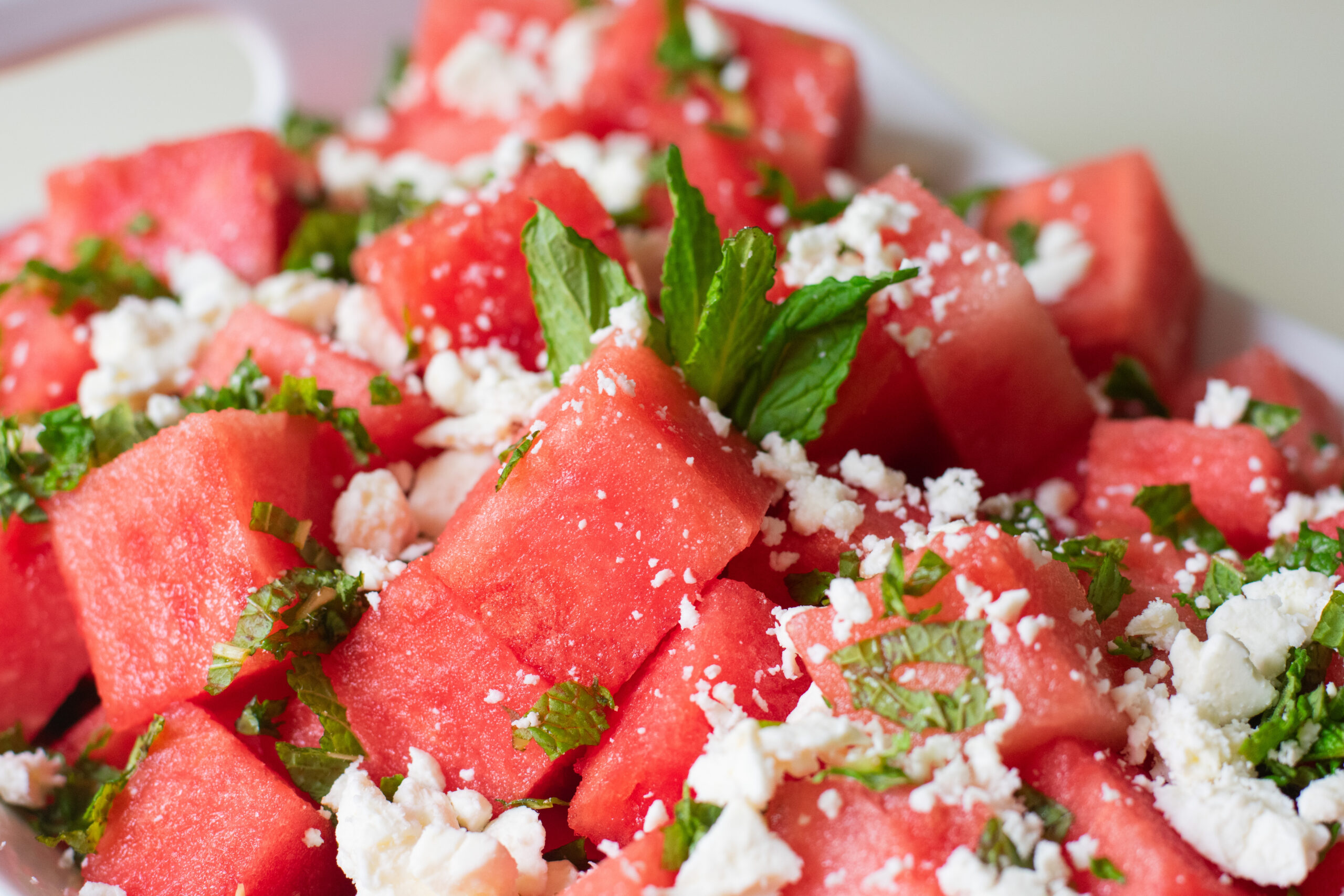 Close-up of watermelon feta salad with fresh mint and lemon dressing, showing juicy cubes and crumbled feta