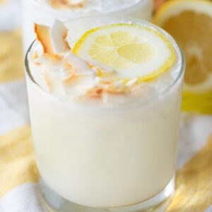 Close-up of a creamy Lemoncoco drink garnished with a lemon slice and toasted coconut flakes on top