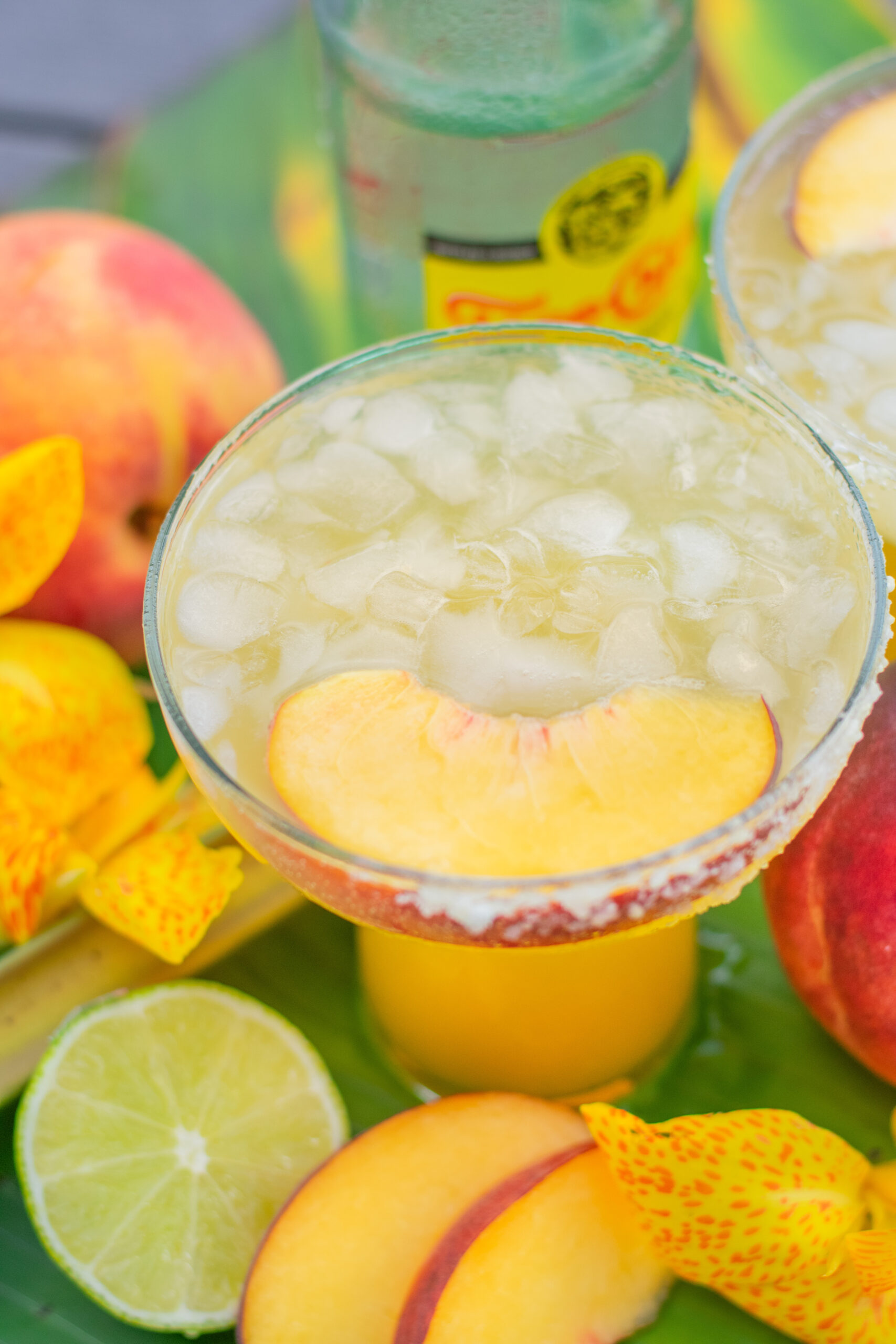 close uo of Peach Margarita Recipe near limes and fresh peaches