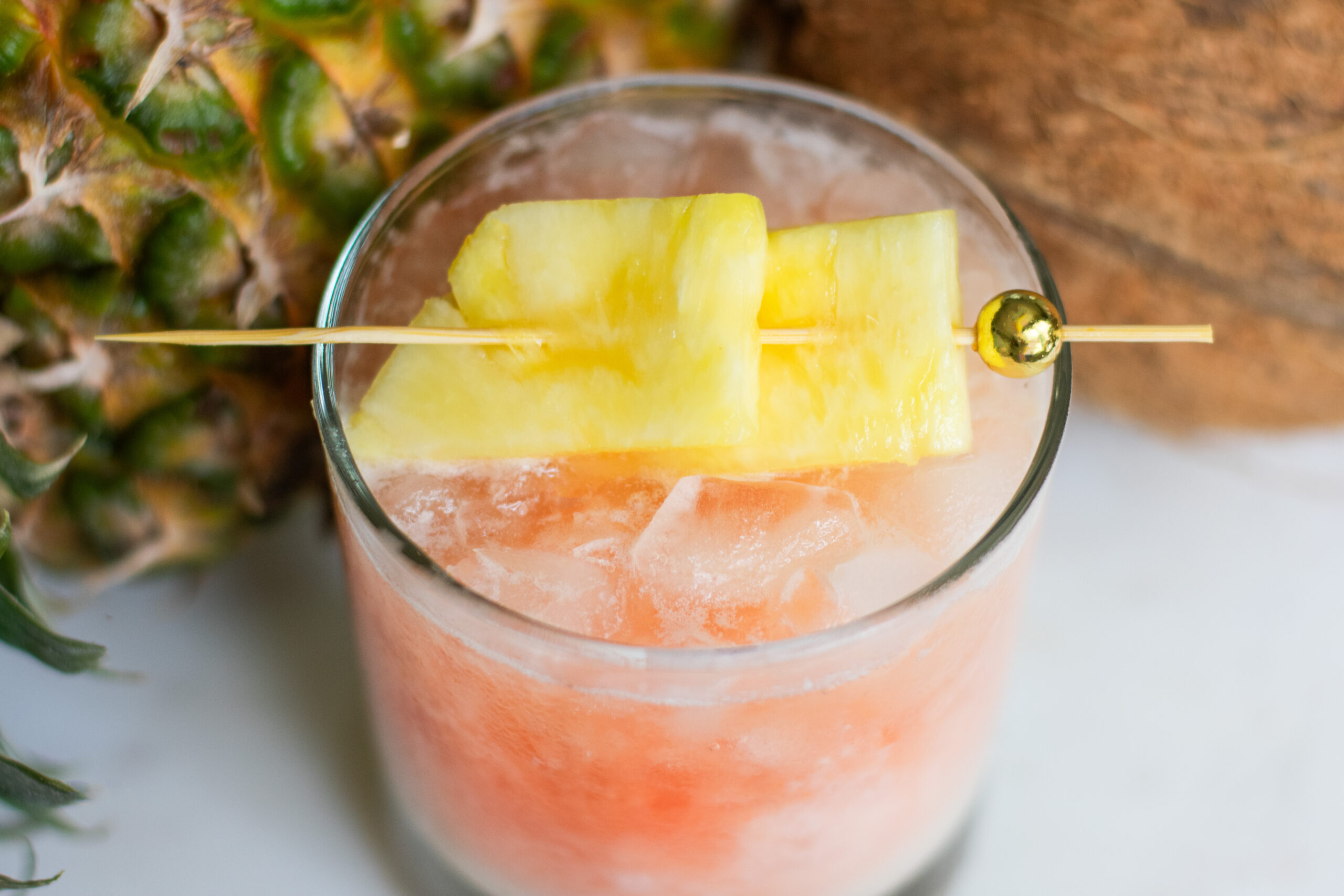 Refreshing Guava Sunrise Colada with pineapple and coconut garnish creating a vacation vibe