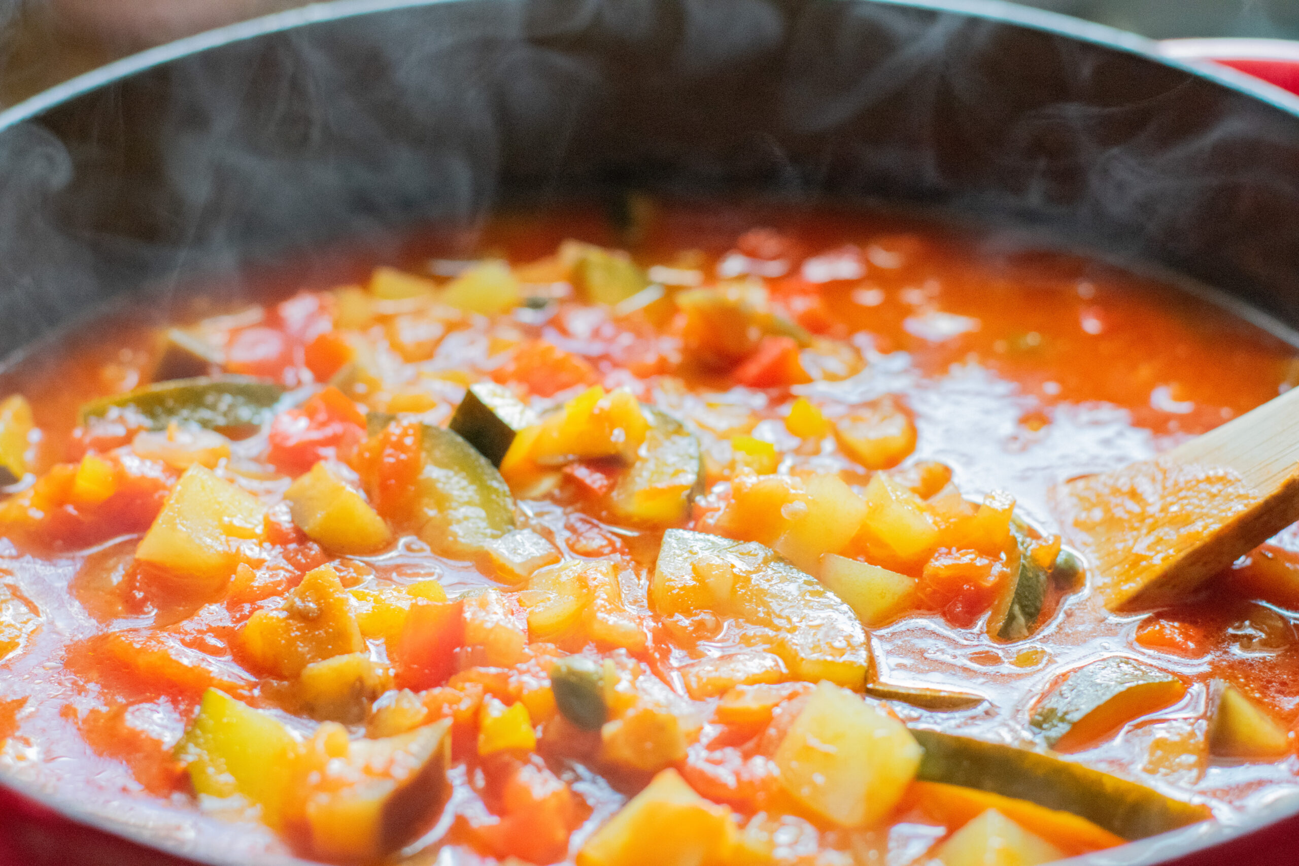 Steaming pot of Giambotta, a rustic Italian vegetable soup with zucchini, eggplant, and tomatoes simmering in tomato broth