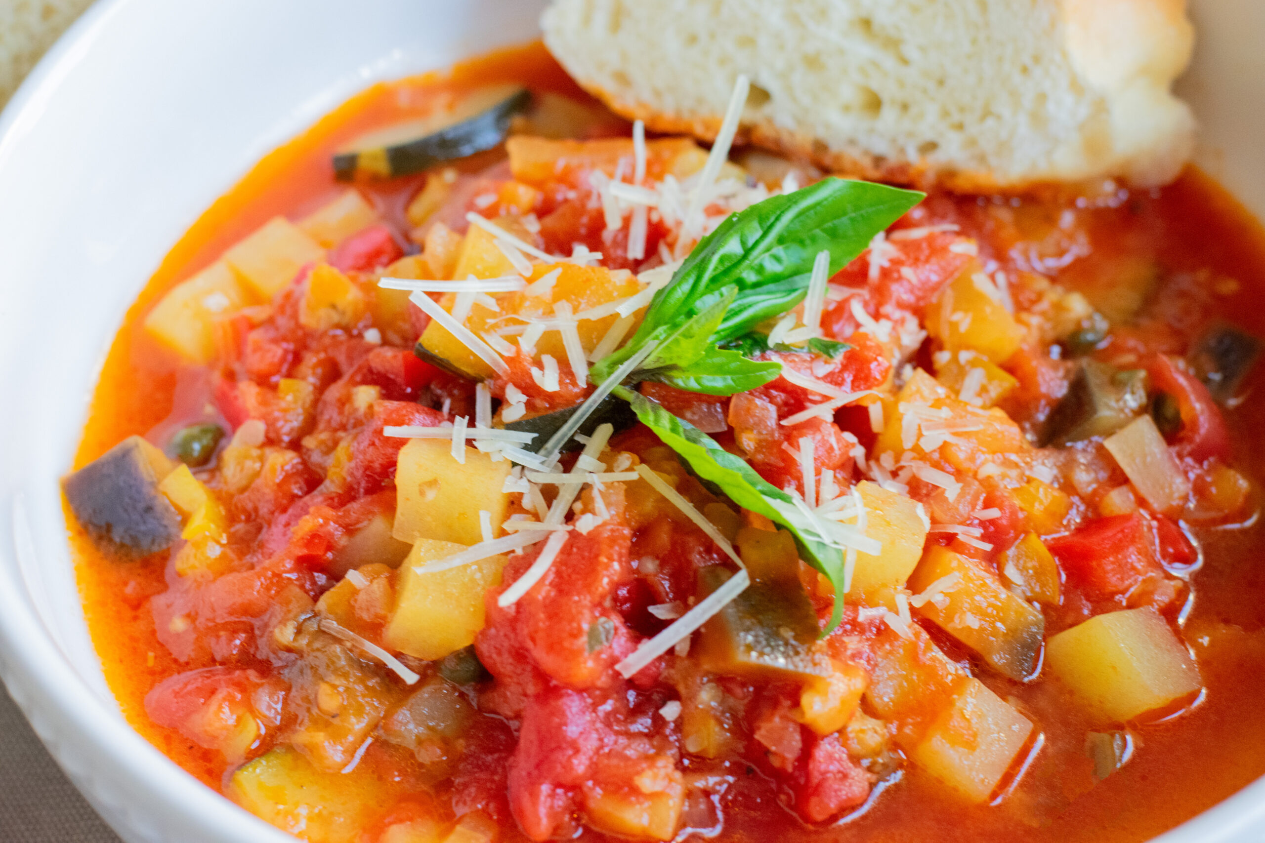 Close-up of Italian vegetable soup, Giambotta, topped with shredded Parmesan cheese