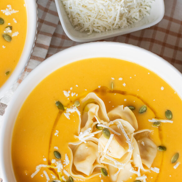 Roasted butternut squash soup with cheese tortellini served in a cozy fall bowl.