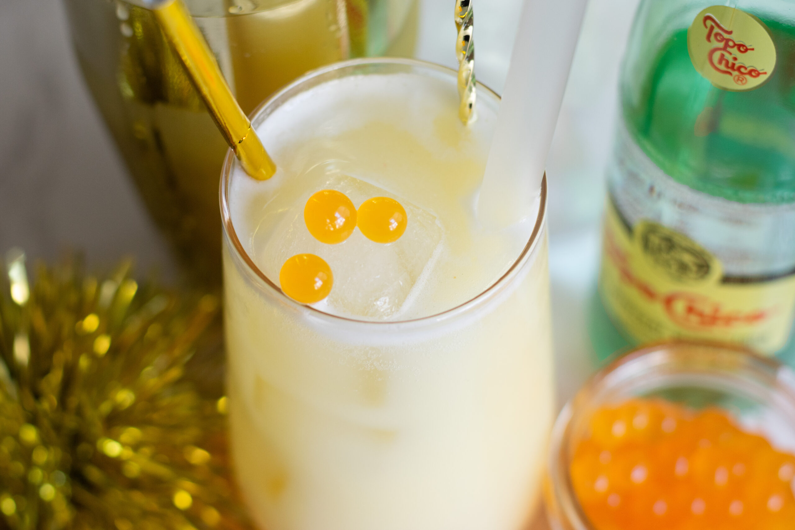 Close up of mango popping boba pearls at the bottom of a tropical mocktail