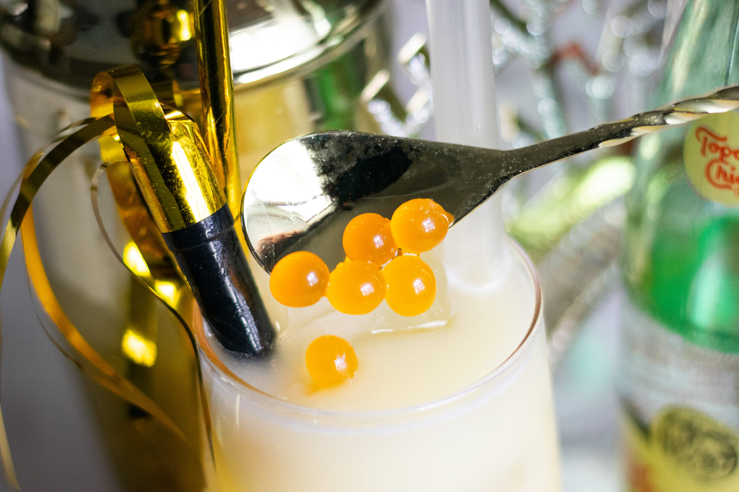 Mango popping boba pearls dropped into a tropical mocktail for New Year’s Eve