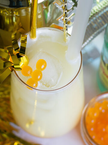 Above shot Mango popping boba drink with coconut water, pineapple juice, and sparkling water in a clear glass