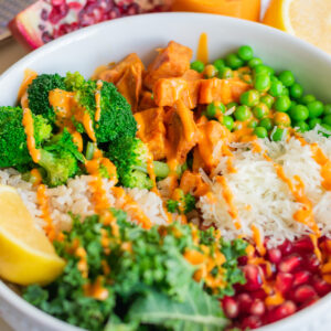 Starbucks-style hearty veggie and brown rice salad with broccoli, sweet potato, peas, kale, pomegranate, and lemon harissa dressing