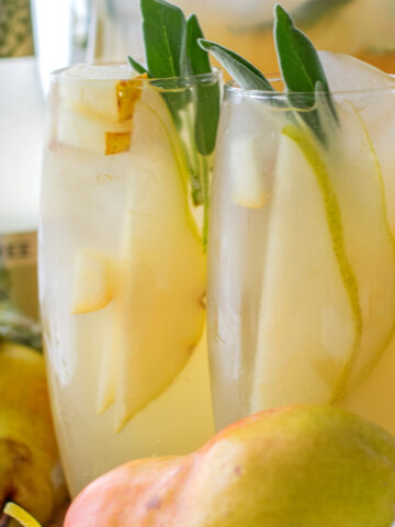 Sage pear mocktail with fresh ginger and lemon, served over ice with sage garnish