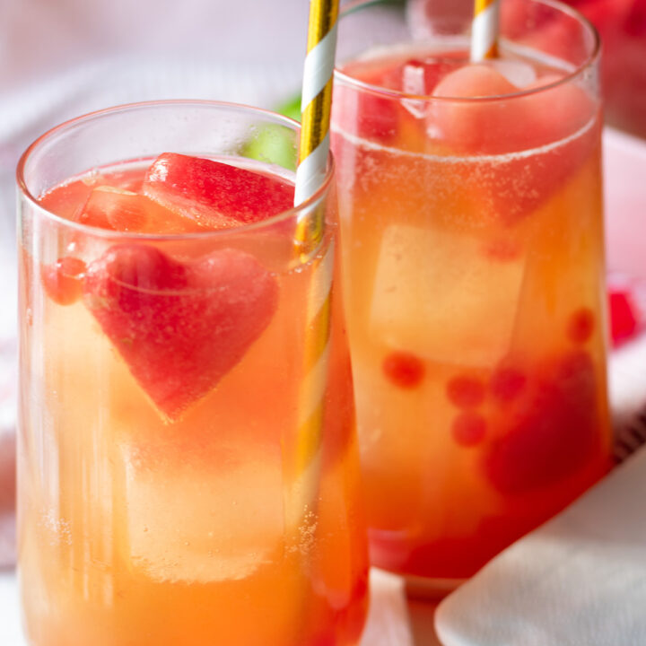 Pink popping boba mocktail with juice, watermelon heart ice cubes, and bubbles