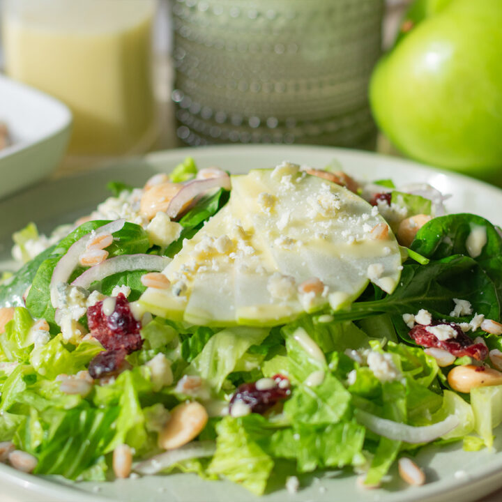 Green apple farro salad with gorgonzola, cranberries, and marcona almonds in a light apple vinaigrette, close-up in a serving bowl