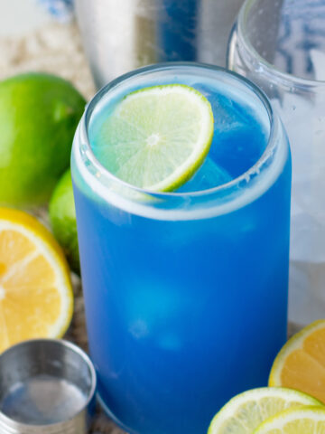 Blue Ocean Water Drink Recipe served over ice with a fresh lime wheel and optional coconut sea foam.
